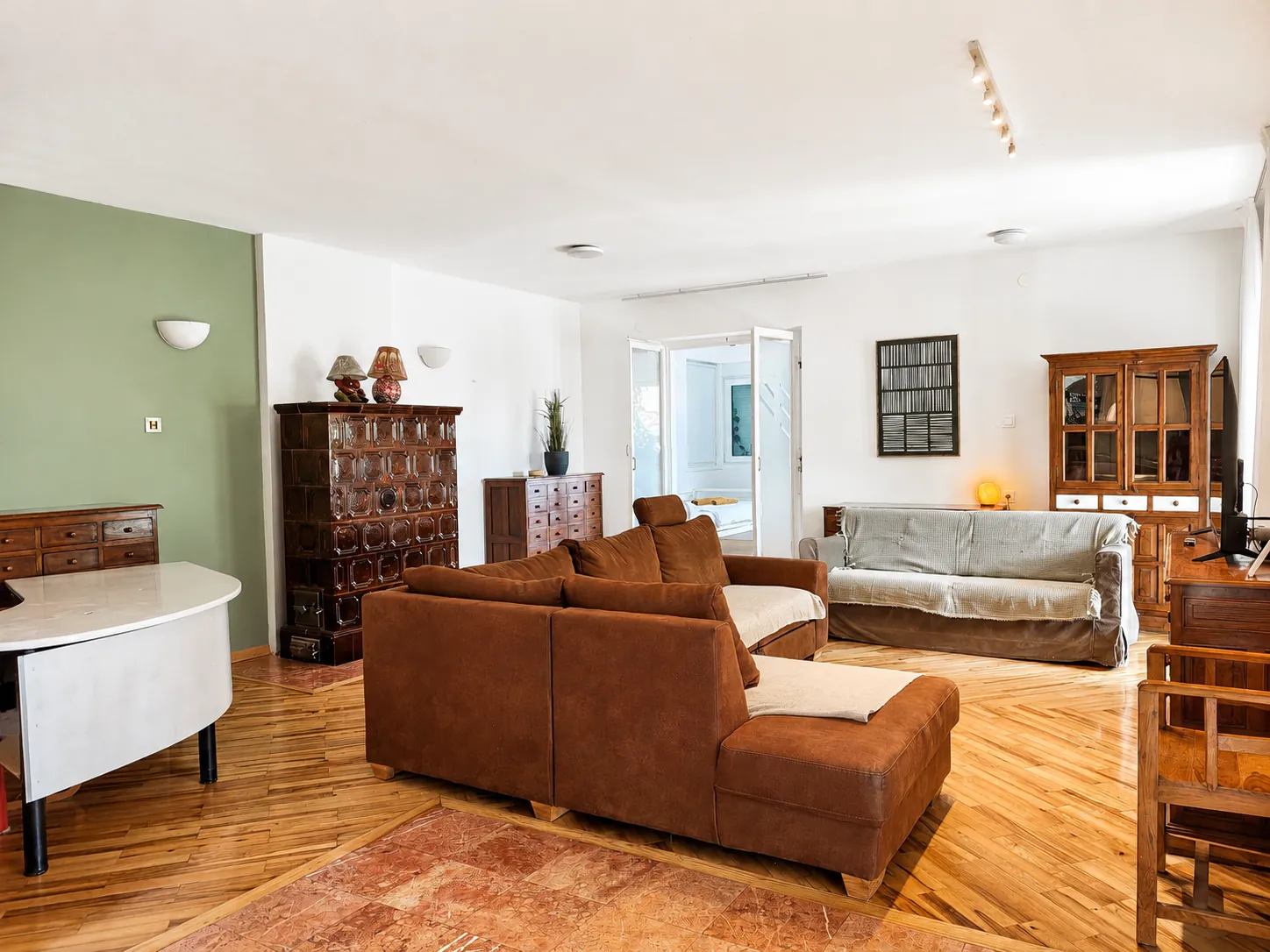 The whole open-plan living space in one room — sofas, the dining area and the kitchen beyond