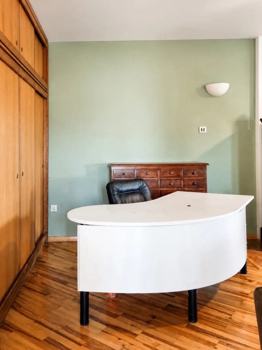 A separate room set up as a home office, with a desk and chair